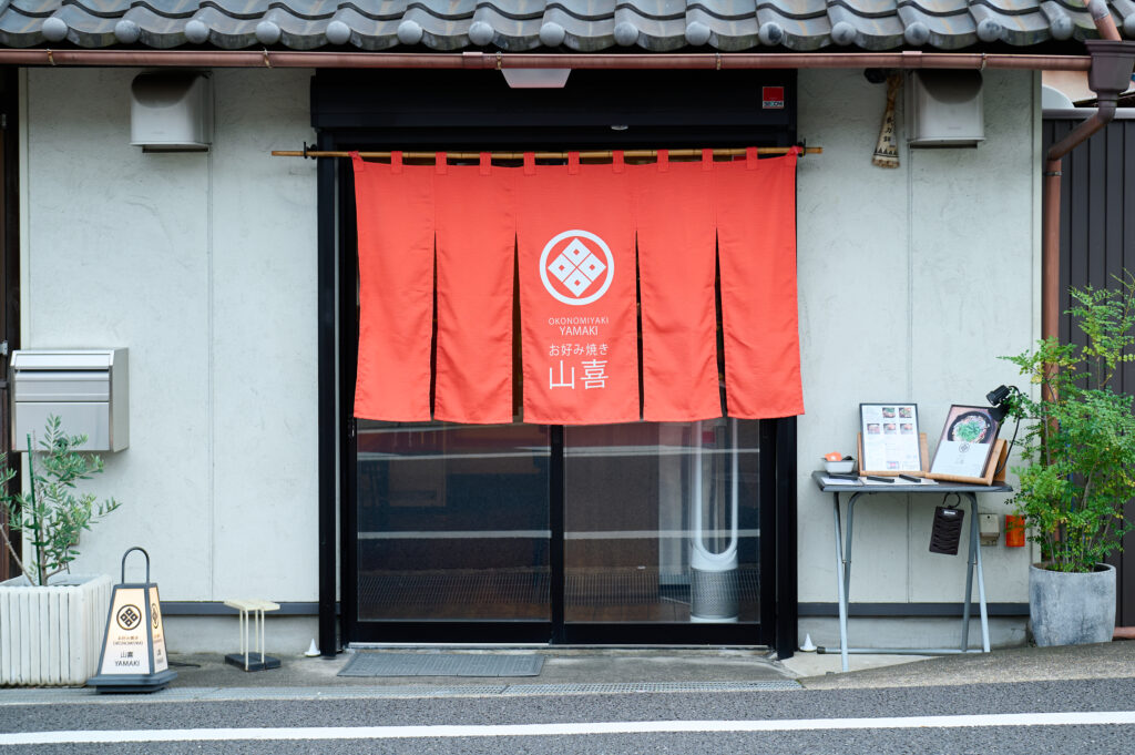 Yamaki storefront with bright orange curtain