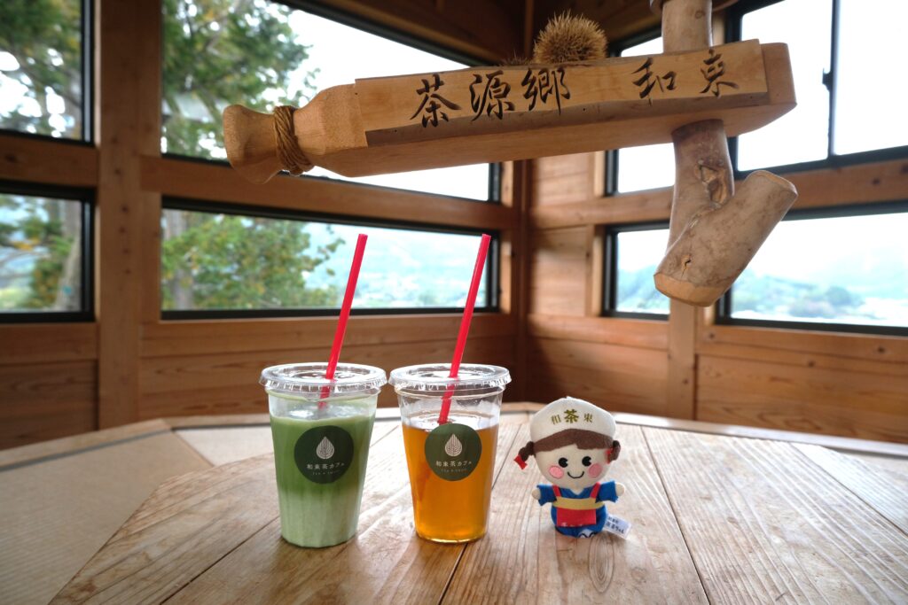 Tea drinks on a wooden table next to a Wazukacha plushie