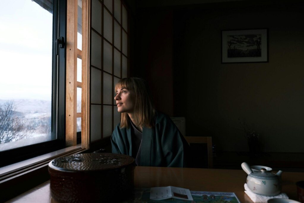 A lady looking out a window in a ryokan