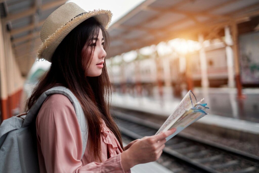 A lady holding a map in a train station