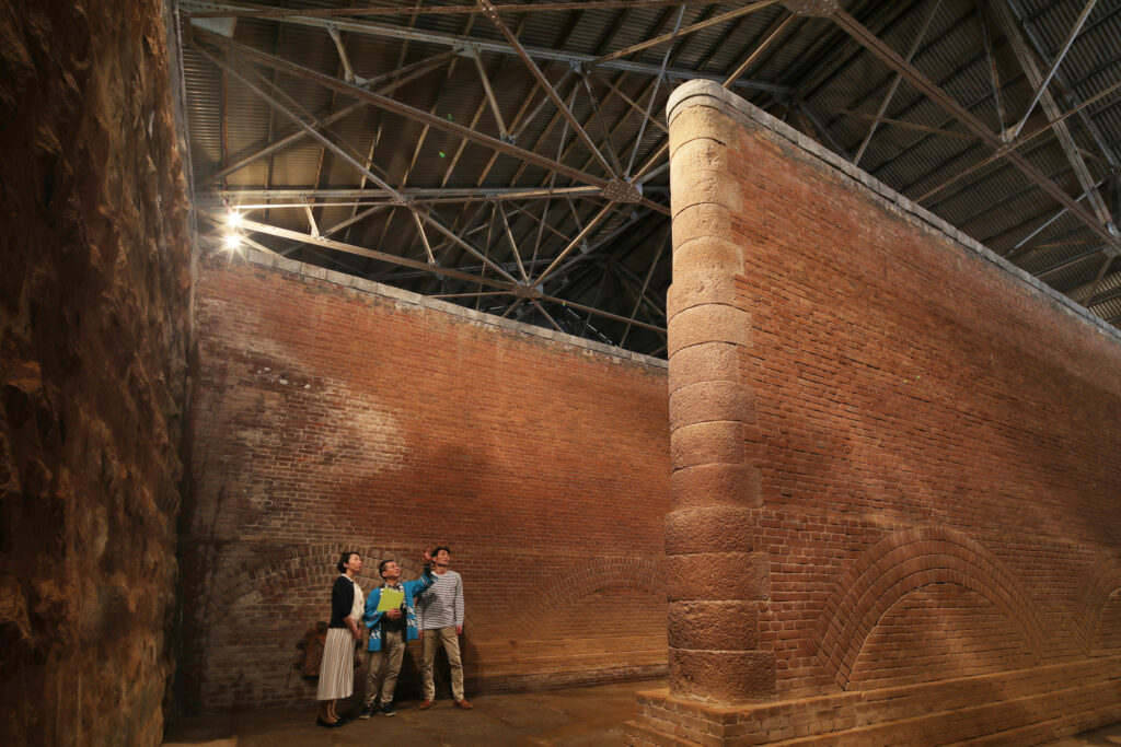 People looking at Kitasui Water Purifcation Plant's 6-meter high brick walls from the holding chamber floor