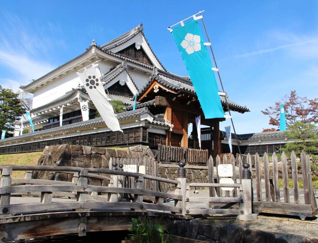 White and blue banners with flower motifs sway in the wind outside of Shoryuji Castle.